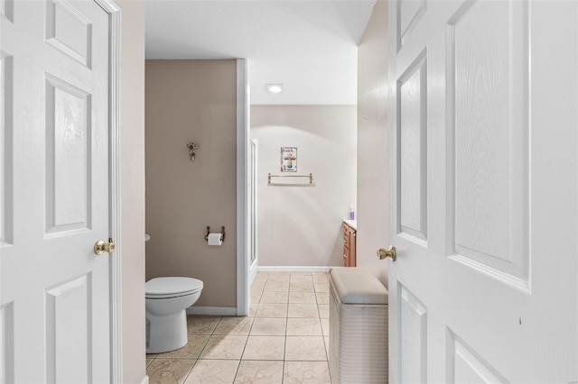 bathroom with a stall shower, baseboards, toilet, tile patterned floors, and vanity