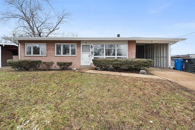 ranch-style home featuring brick siding, concrete driveway, and a front yard