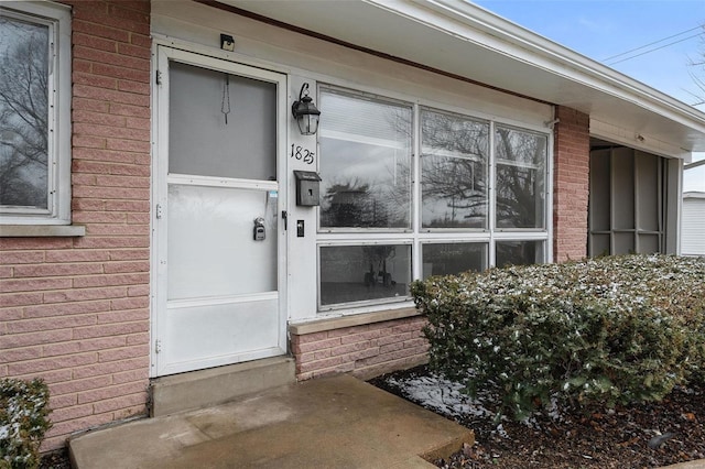 doorway to property with brick siding