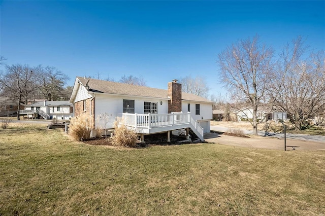 rear view of house featuring an attached garage, driveway, a yard, a wooden deck, and a chimney