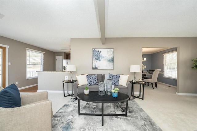 living area featuring light carpet, baseboards, and beam ceiling