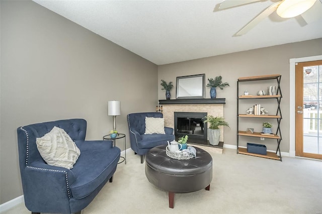 living area featuring baseboards, a ceiling fan, a glass covered fireplace, lofted ceiling, and carpet