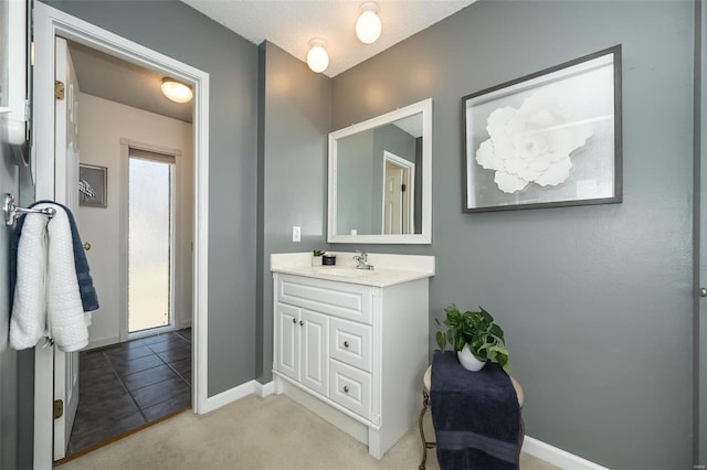 bathroom with tile patterned floors, vanity, and baseboards