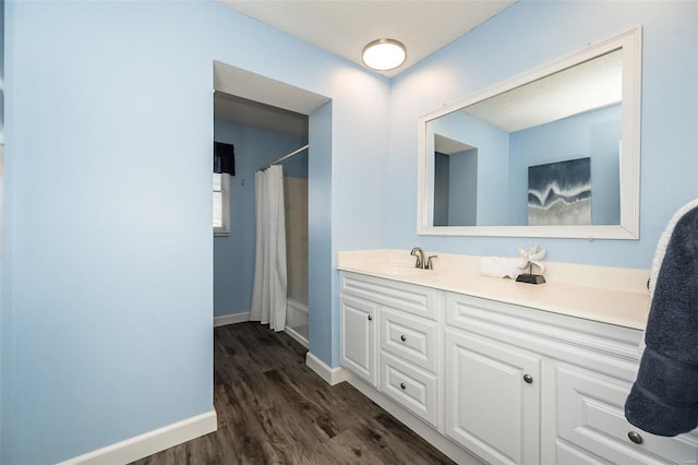 full bathroom with vanity, baseboards, and wood finished floors