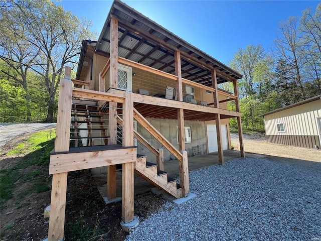 view of outdoor structure with an attached garage and gravel driveway