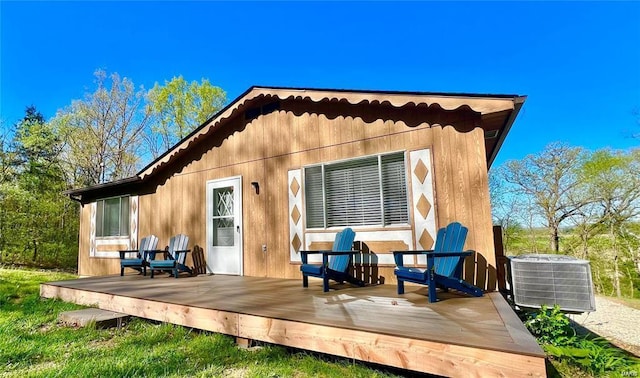 rear view of house with cooling unit and a wooden deck