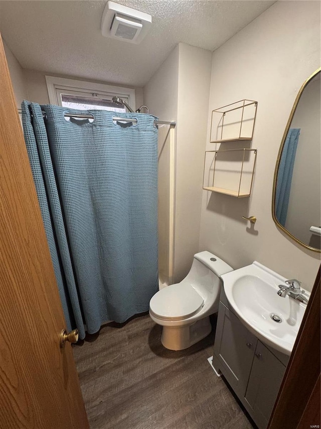 bathroom featuring visible vents, a shower with curtain, wood finished floors, a textured ceiling, and vanity