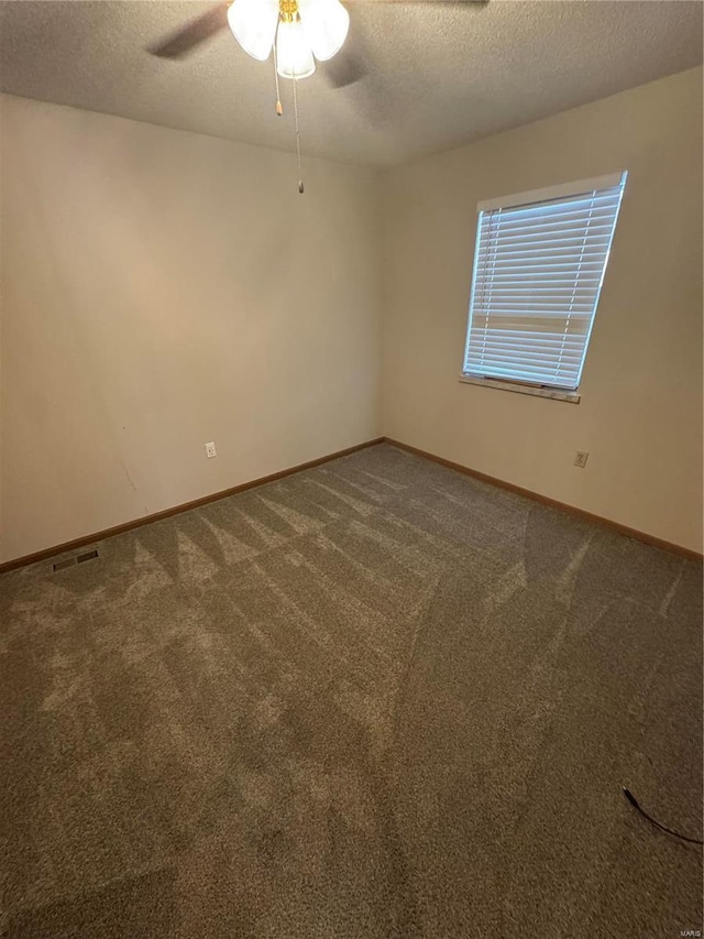 unfurnished room with carpet, baseboards, ceiling fan, and a textured ceiling