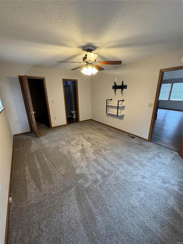 interior space featuring carpet, ceiling fan, a textured ceiling, and baseboards