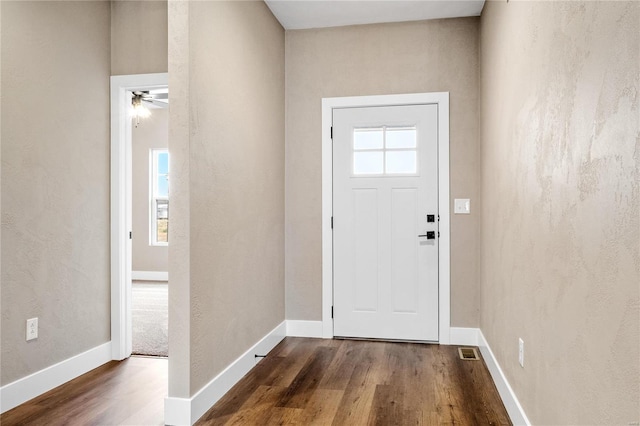 entrance foyer featuring visible vents, baseboards, and dark wood-type flooring