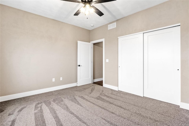 unfurnished bedroom featuring visible vents, baseboards, carpet, and a closet