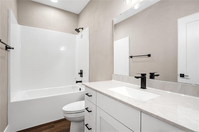 full bath with washtub / shower combination, toilet, wood finished floors, and vanity