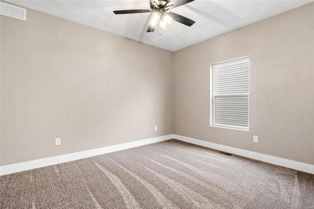 carpeted empty room with visible vents, a ceiling fan, and baseboards