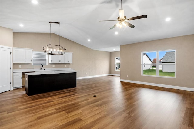 kitchen featuring a kitchen island, light wood-style flooring, light countertops, white cabinetry, and open floor plan