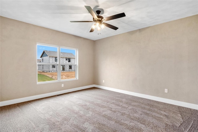 spare room featuring visible vents, a ceiling fan, baseboards, and carpet floors