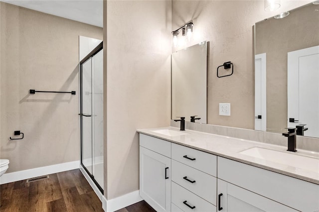 full bathroom with a shower stall, wood finished floors, and a sink