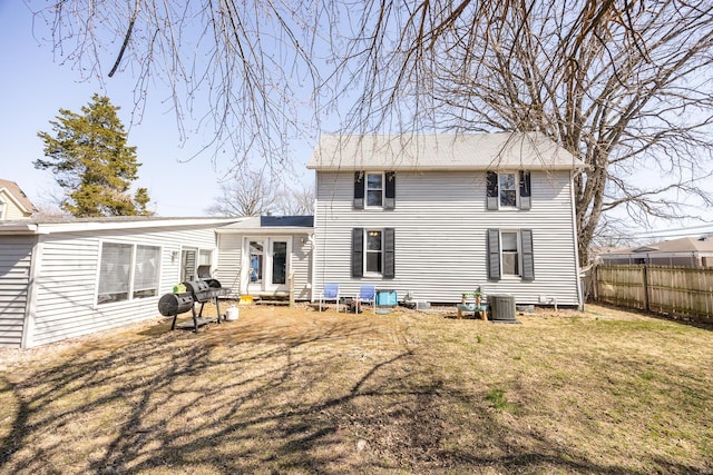 back of house with a yard, fence, and central AC