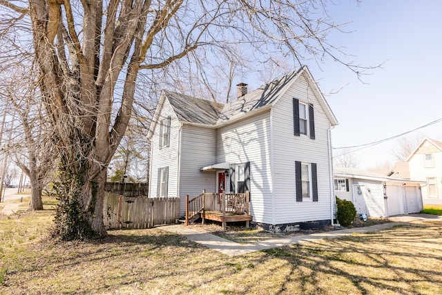 view of front of property featuring a wooden deck, a chimney, a garage, and fence