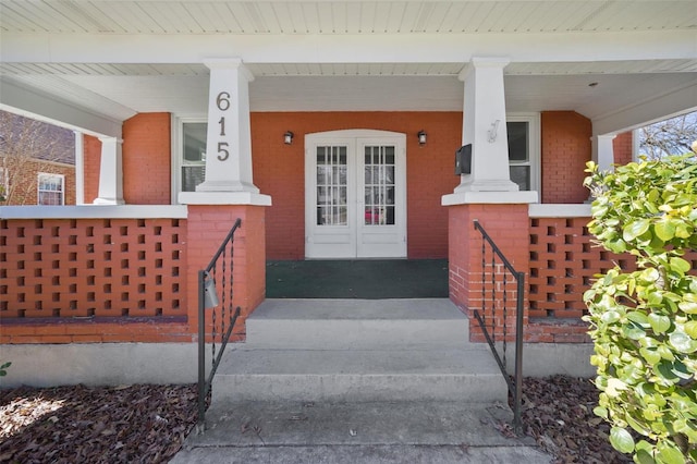 property entrance with covered porch and brick siding