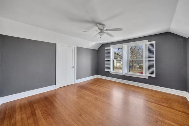 additional living space featuring baseboards, vaulted ceiling, and wood finished floors