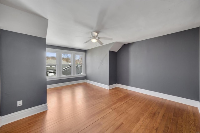 interior space featuring a ceiling fan, baseboards, and wood finished floors