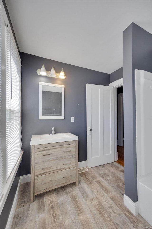 bathroom featuring vanity, baseboards, and wood finished floors