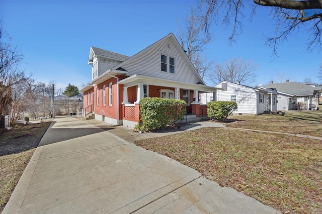 view of side of property featuring concrete driveway, brick siding, and a lawn