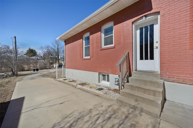 view of side of property with entry steps and brick siding