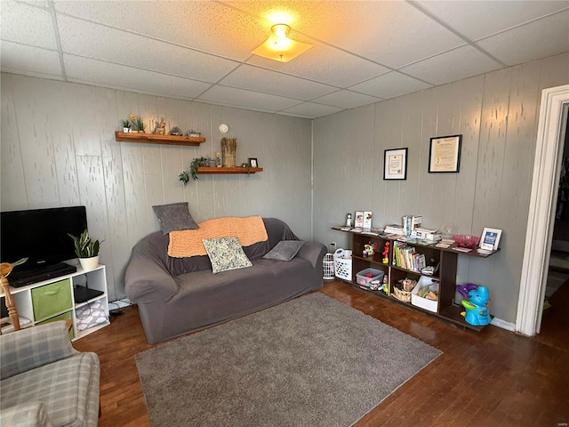 living area featuring a paneled ceiling and wood finished floors