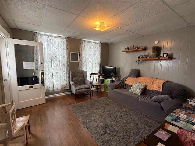 living room featuring a drop ceiling and wood-type flooring