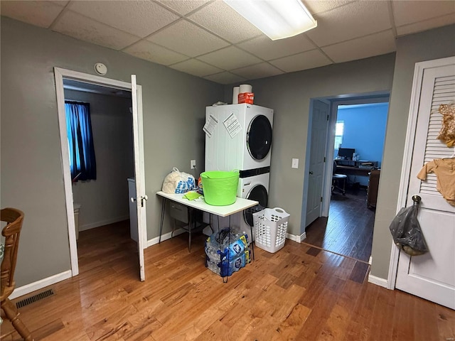 interior space featuring laundry area, wood finished floors, visible vents, baseboards, and stacked washer and clothes dryer