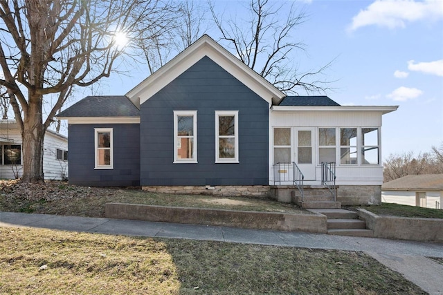 bungalow-style house featuring a sunroom and a shingled roof