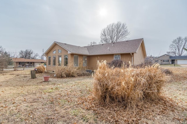 back of property featuring a shingled roof