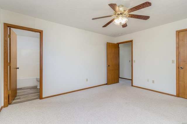 spare room featuring ceiling fan, baseboards, and light colored carpet