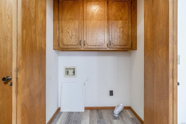 washroom with cabinet space, hookup for a washing machine, baseboards, and wood finished floors