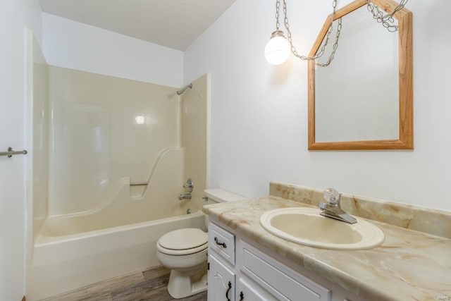 bathroom with vanity, shower / bathing tub combination, wood finished floors, and toilet