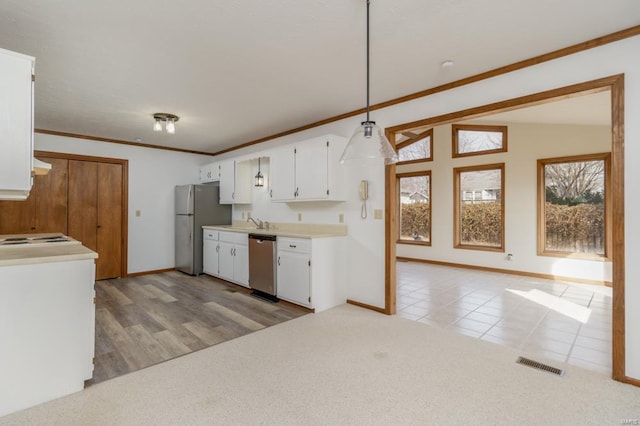 kitchen with stainless steel appliances, light countertops, light colored carpet, visible vents, and white cabinetry