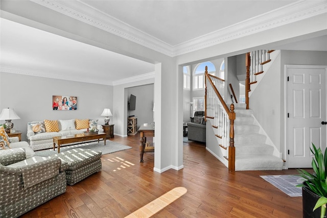 living area with stairway, ornamental molding, baseboards, and hardwood / wood-style floors