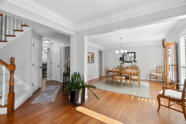 dining space with baseboards, an inviting chandelier, stairs, and hardwood / wood-style flooring