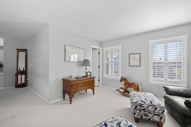 living area with baseboards and carpet flooring