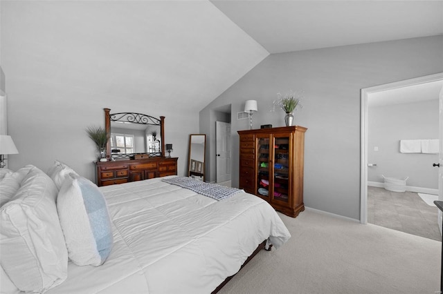 bedroom featuring ensuite bathroom, baseboards, lofted ceiling, and carpet