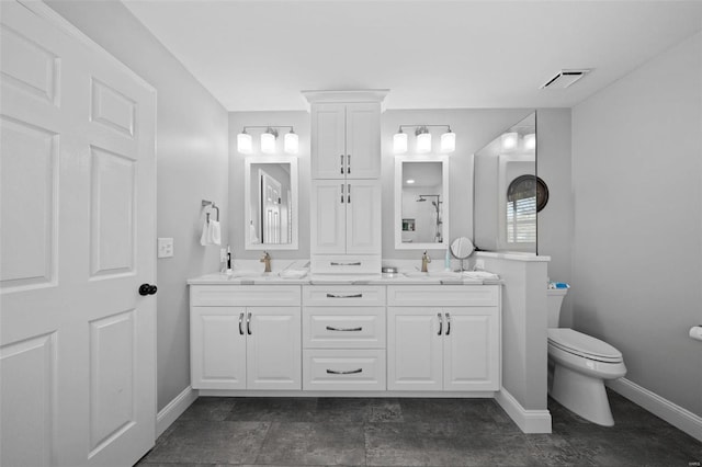 bathroom featuring double vanity, visible vents, toilet, and a sink