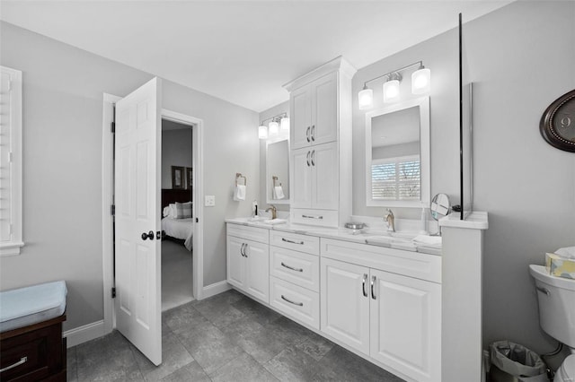 full bathroom featuring a sink, baseboards, and double vanity