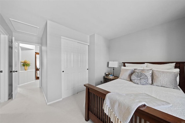 bedroom featuring baseboards, a closet, light carpet, and attic access