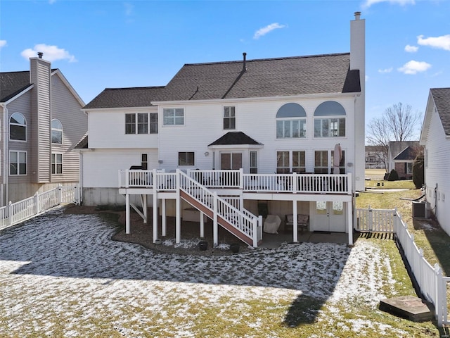 back of house with a deck, central air condition unit, a fenced backyard, and a chimney