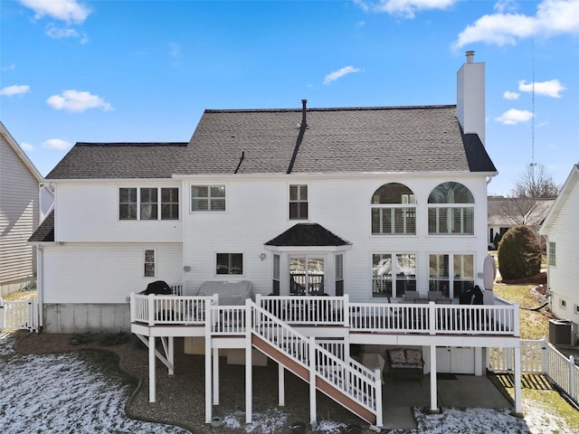 back of property featuring a shingled roof, stairs, central AC, a chimney, and a deck