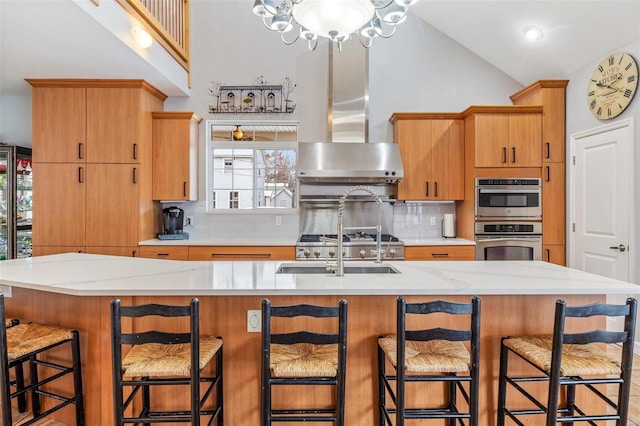 kitchen with extractor fan, stainless steel double oven, a kitchen island with sink, and decorative backsplash