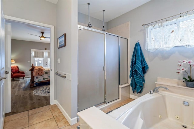 bathroom with baseboards, a tub with jets, tile patterned floors, ensuite bathroom, and a shower stall