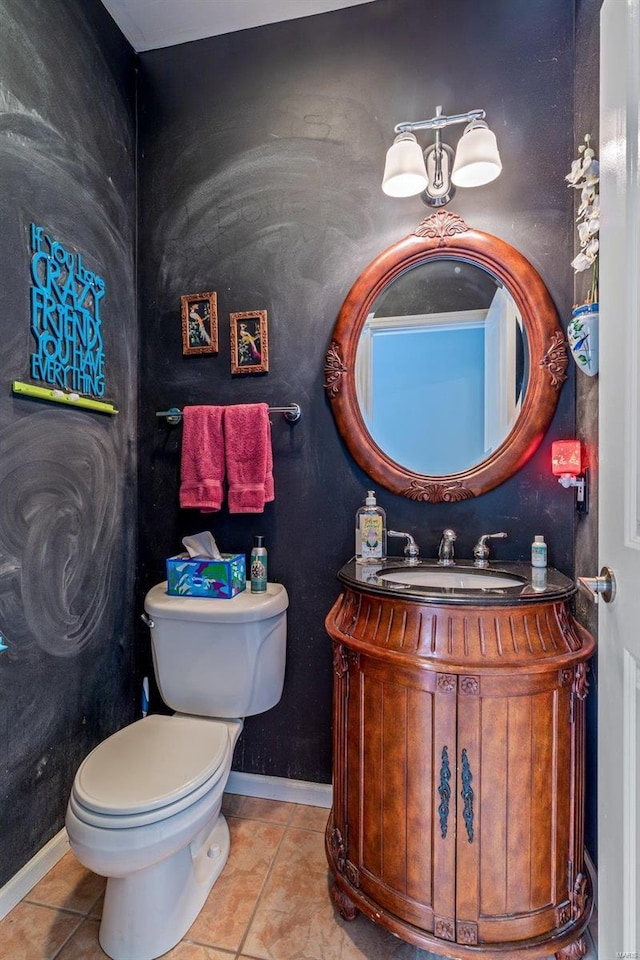 half bathroom featuring baseboards, vanity, toilet, and tile patterned floors