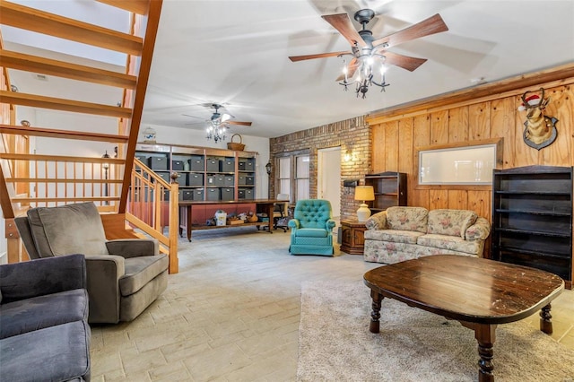 living room with wood walls, stairs, and a ceiling fan